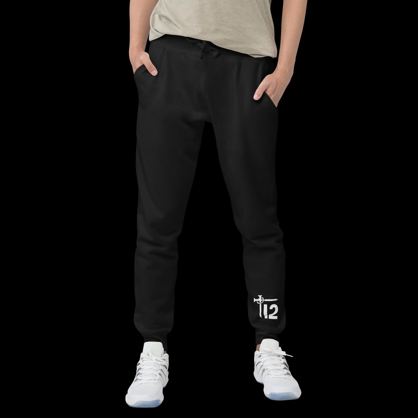 Black Christian Sweatpants – Unisex fleece joggers with white embroidered “12T” logo featuring cross nail and crown of thorns design on leg, faith-inspired streetwear modeled with sneakers.