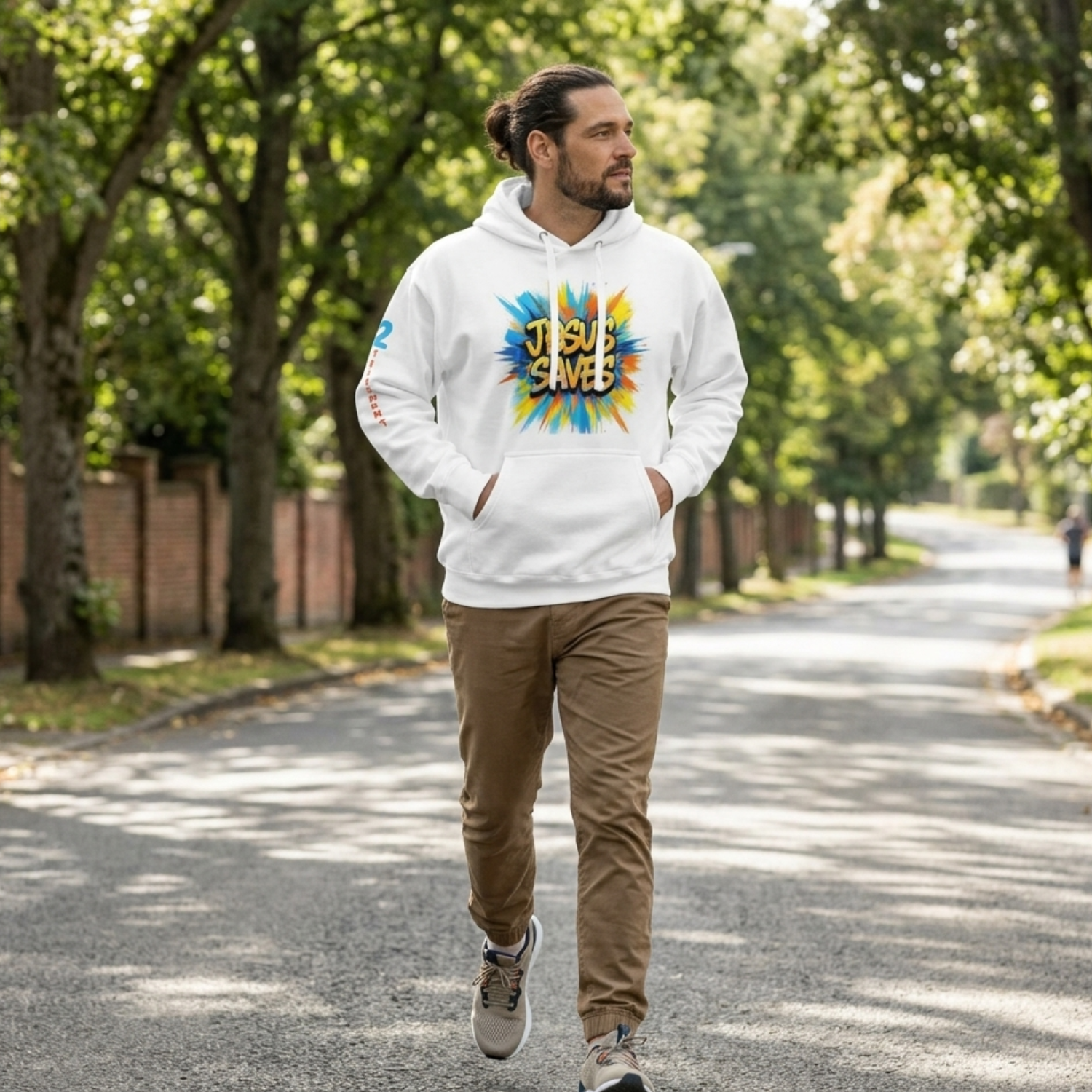 Man walking outdoors wearing a white “Jesus Saves” Christian hoodie with colorful graphic, modeling faith-based streetwear apparel.