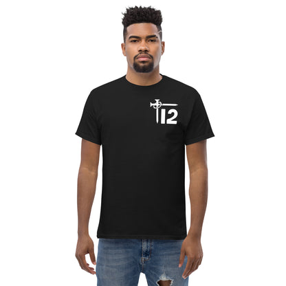 Black Christian Men’s T-Shirt – Classic short-sleeve tee featuring white “12T” logo with cross nail and crown of thorns design, faith-based apparel modeled with ripped jeans.