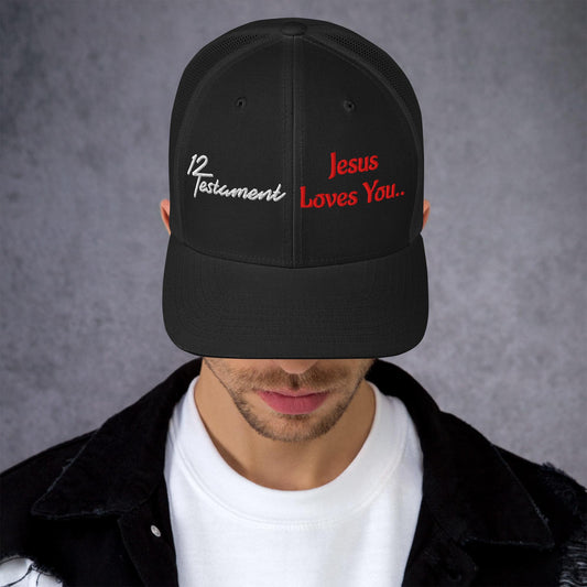 Black Christian trucker hat featuring 12 Testament logo and Jesus Loves You embroidered design on front panel.